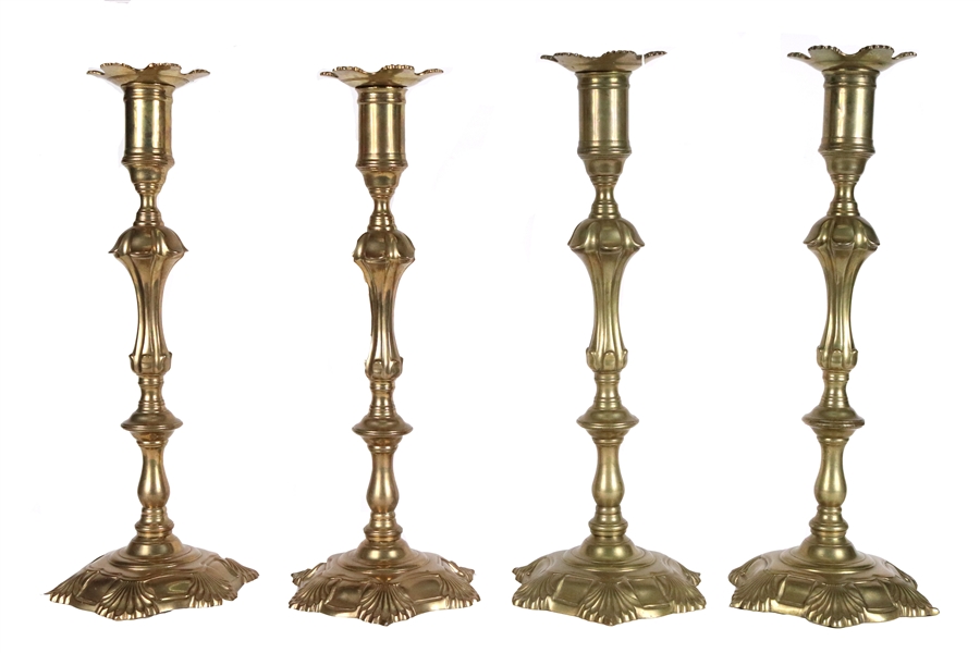 Four George III Cast Brass Shell Base Candlesticks